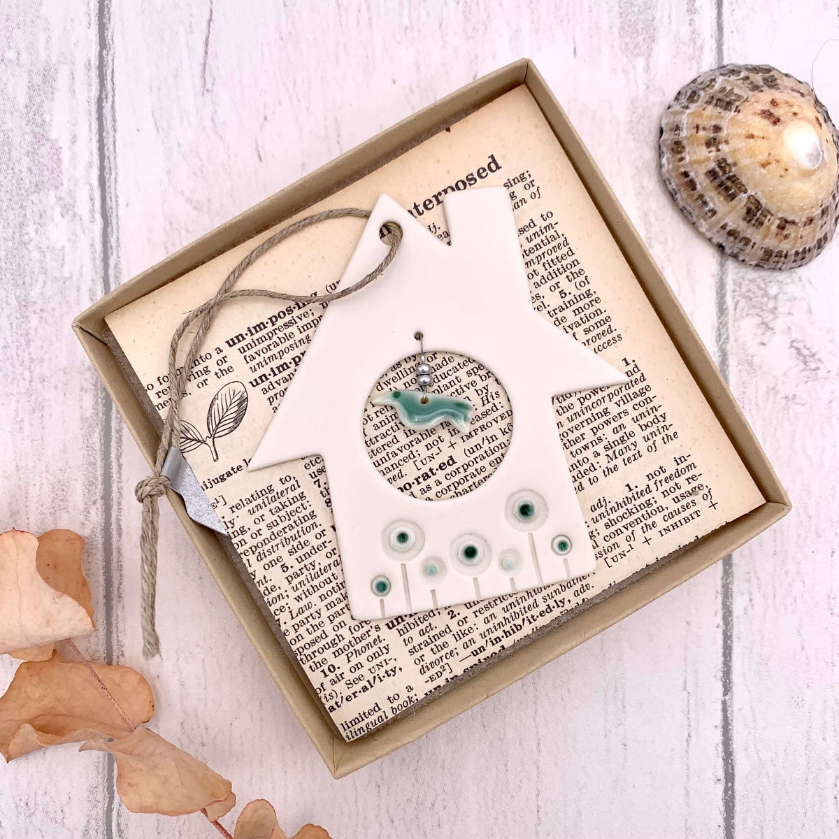 Handmade in the UK, boxed porcelain hanging of a house and bird, with glazed detailing and glass beads.