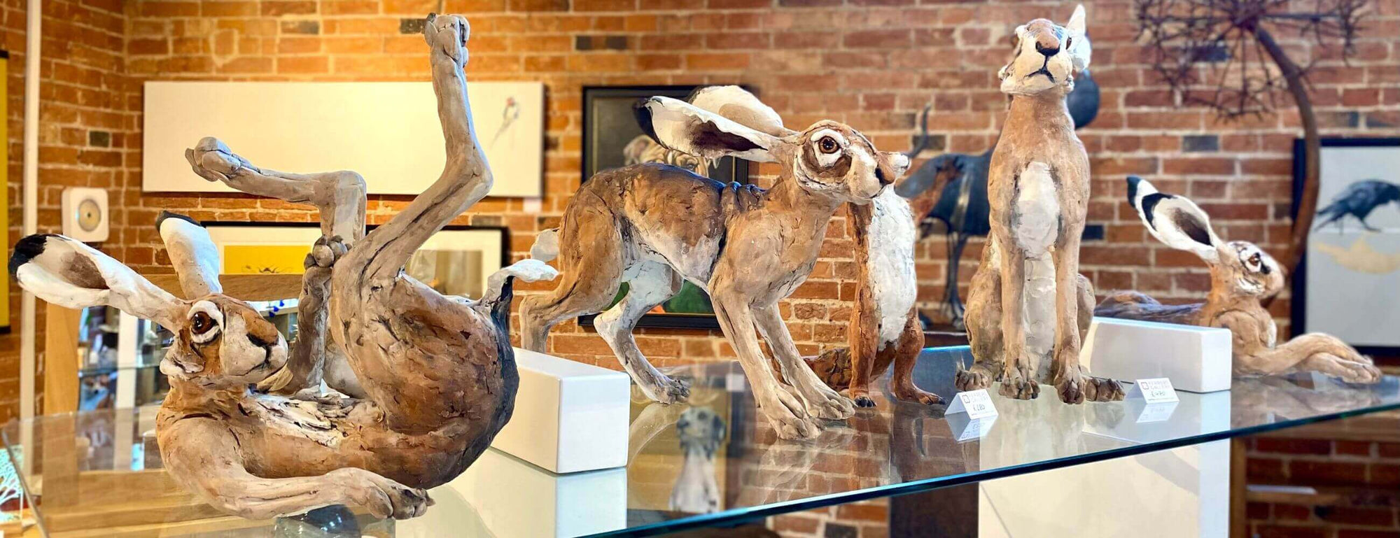 Collection of Louise Brown handcrafted ceramic hare sculptures at Ferrers Gallery.