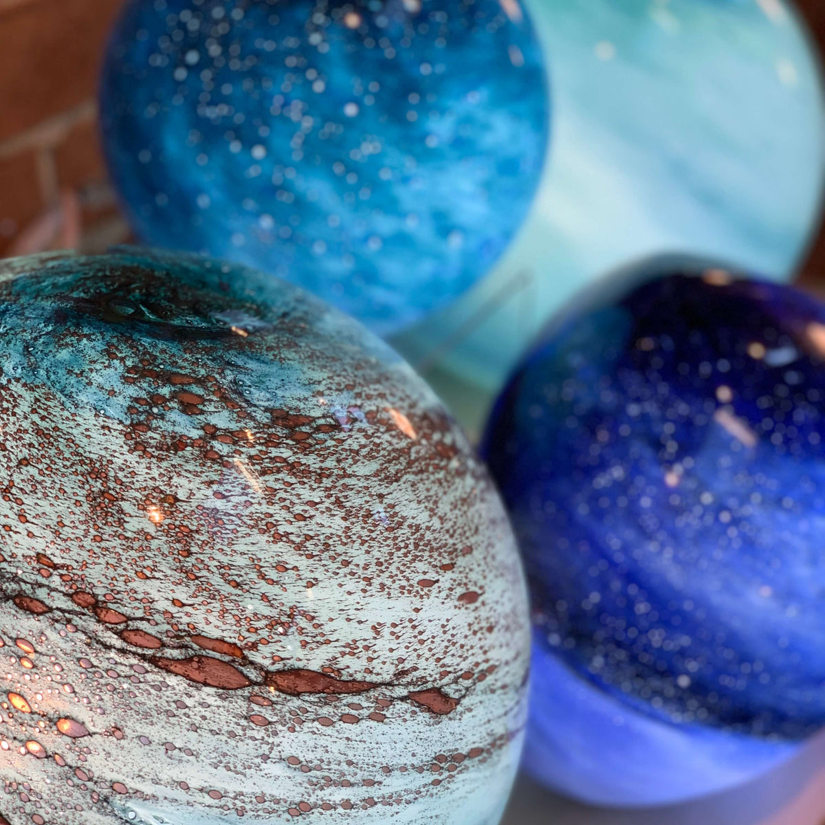 A cluster of our blown glass orb lights, handmade with planet like colouring and a smooth surface. Available at Ferrers Gallery.