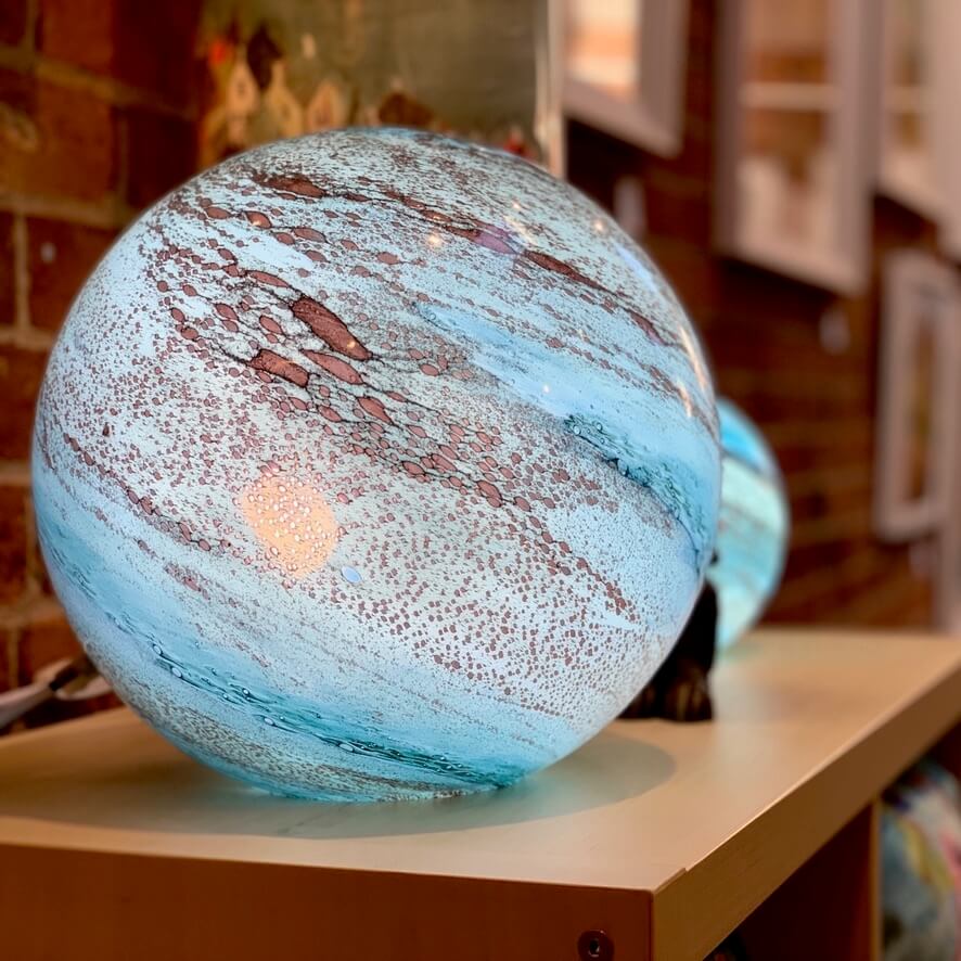 Blown glass orb lights, handmade with planet like colouring and a smooth surface. Available at Ferrers Gallery.