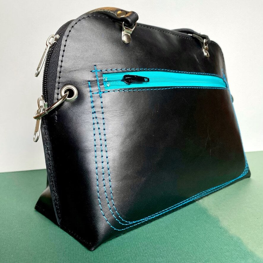 Womens black leather handbag with blue zip details. Handmade in the uk.