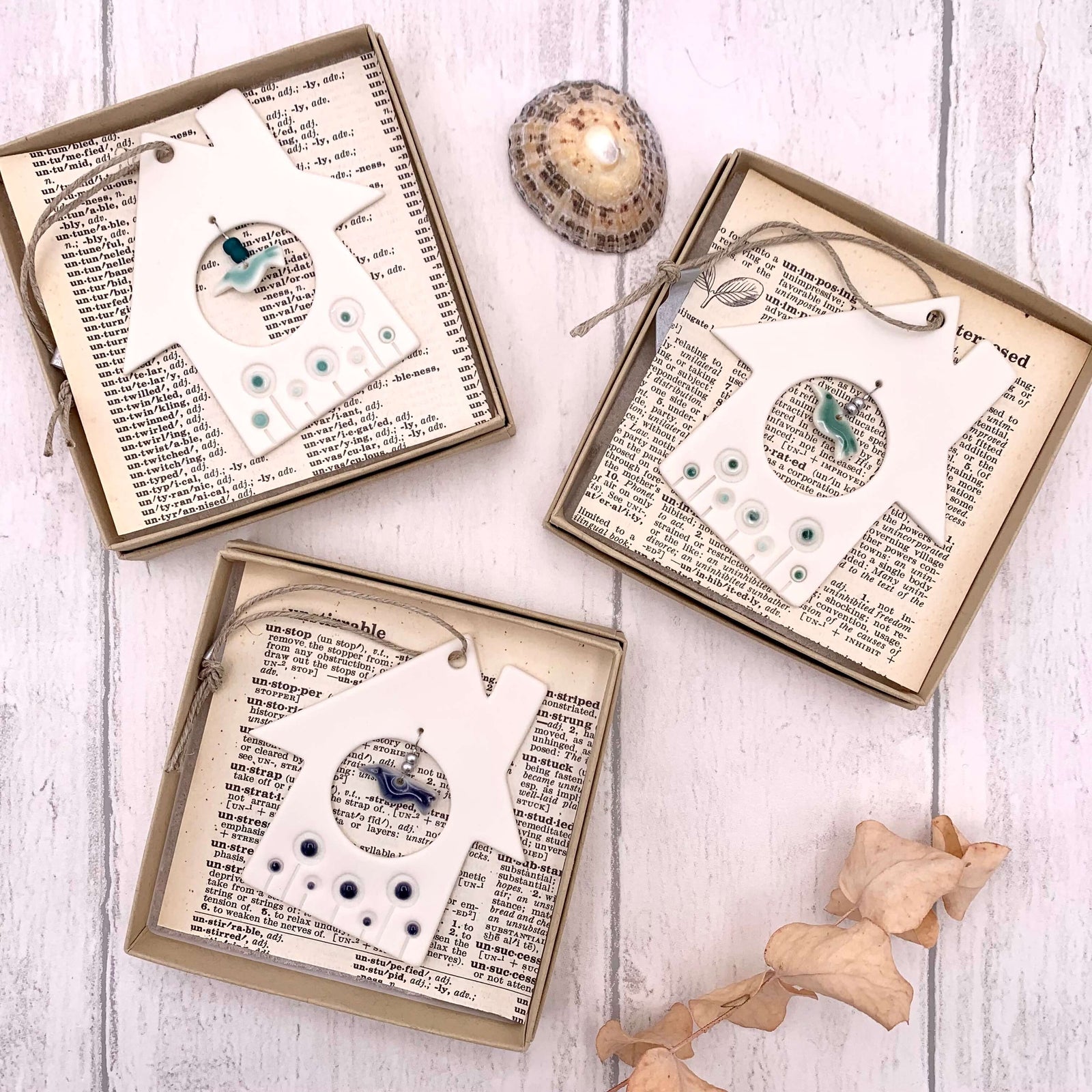 Handmade in the UK, boxed porcelain hanging of a house and bird, with glazed detailing and glass beads.