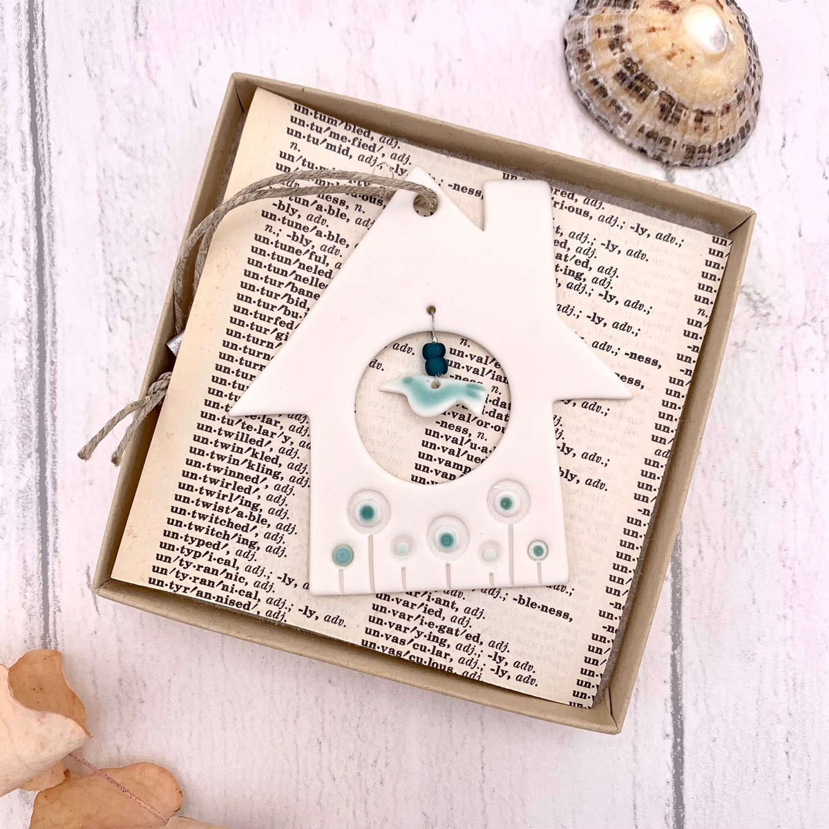 Handmade in the UK, boxed porcelain hanging of a house and bird, with green glazed detailing and glass beads.