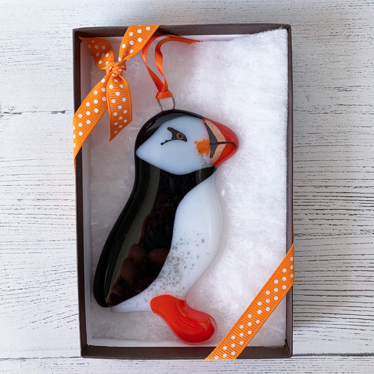 Handmade Boxed Fused Glass Puffin hanging, by Sarah Myatt. With orange spotted ribbon on box.