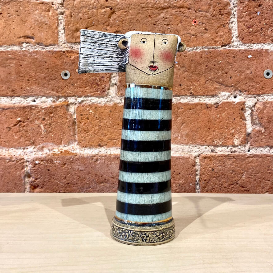 Sarah Saunders handcrafted tall ceramic sculpture, of a white haired lady with a striped body.